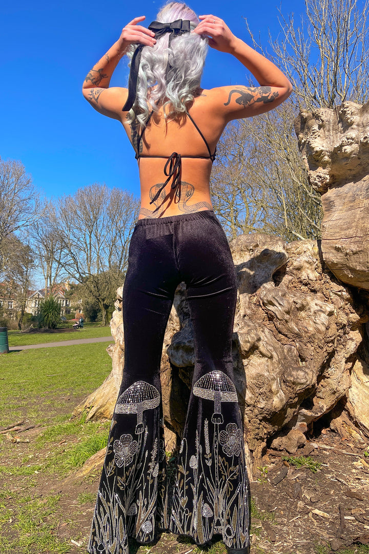 Back view of The Fairy Garden Catsuit outdoors, showing open-back halter tie and sequin mushroom flares. Alternative fashion for festivals.