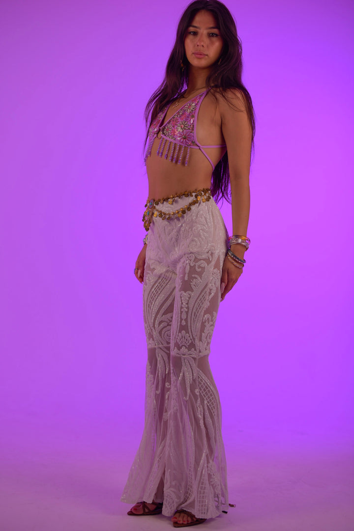 Model posing in Swan Flares, white embroidered flared pants for alternative rave and festival fashion from Wild Thing.