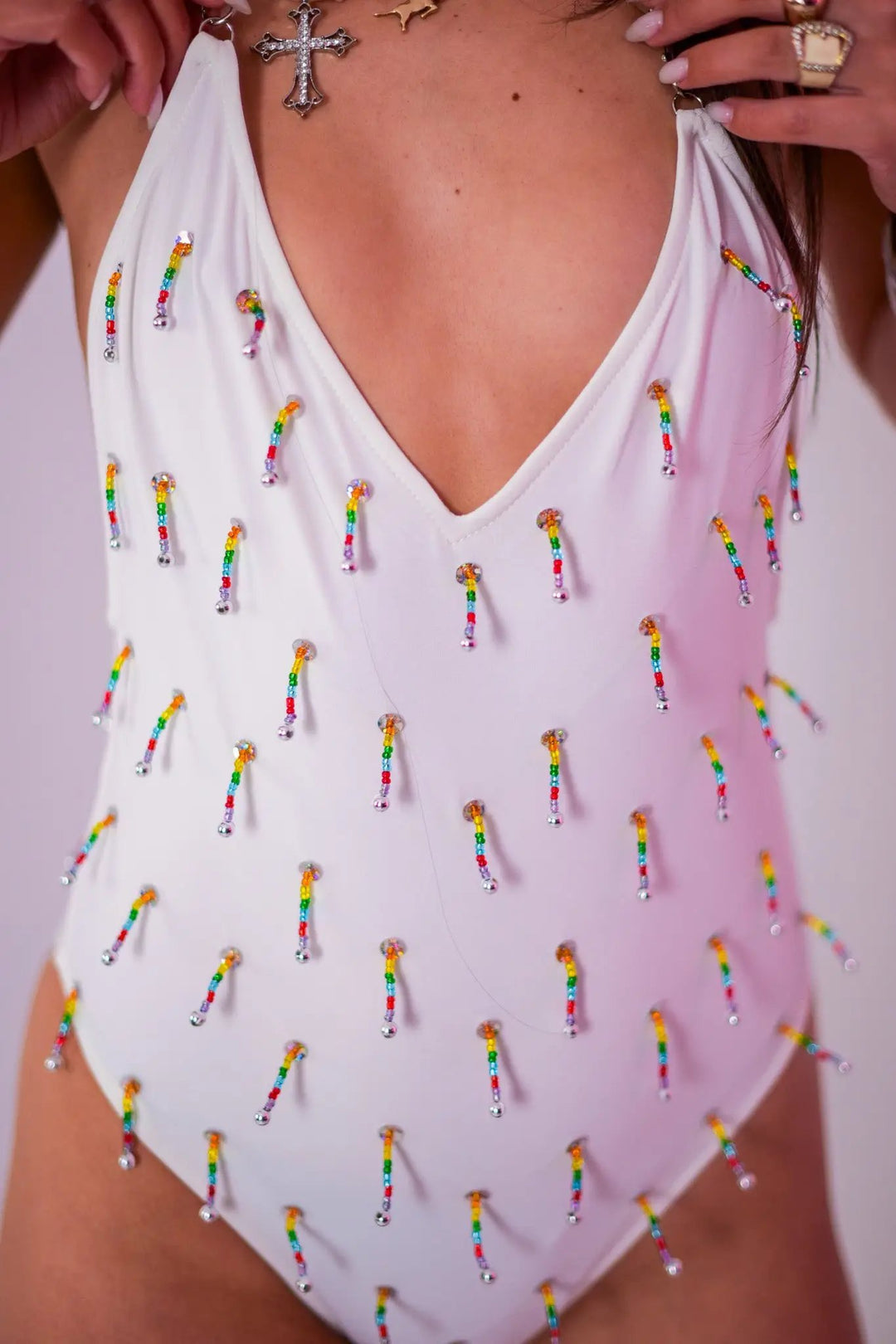 Detailed front close-up of White Beaded Swim Bodysuit highlighting rainbow beaded embellishments on white fabric for rave fashion.