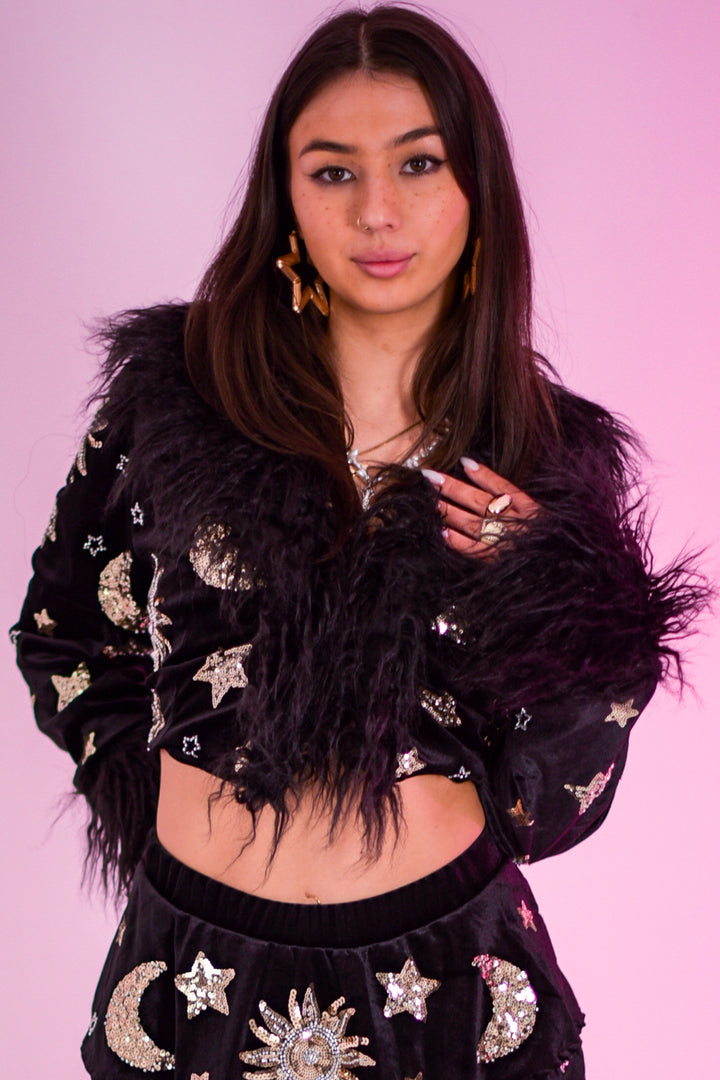 Close-up of The Phase Cropped Jacket showing detailed sequin embellishments and shaggy faux fur collar, styled for festival wear.