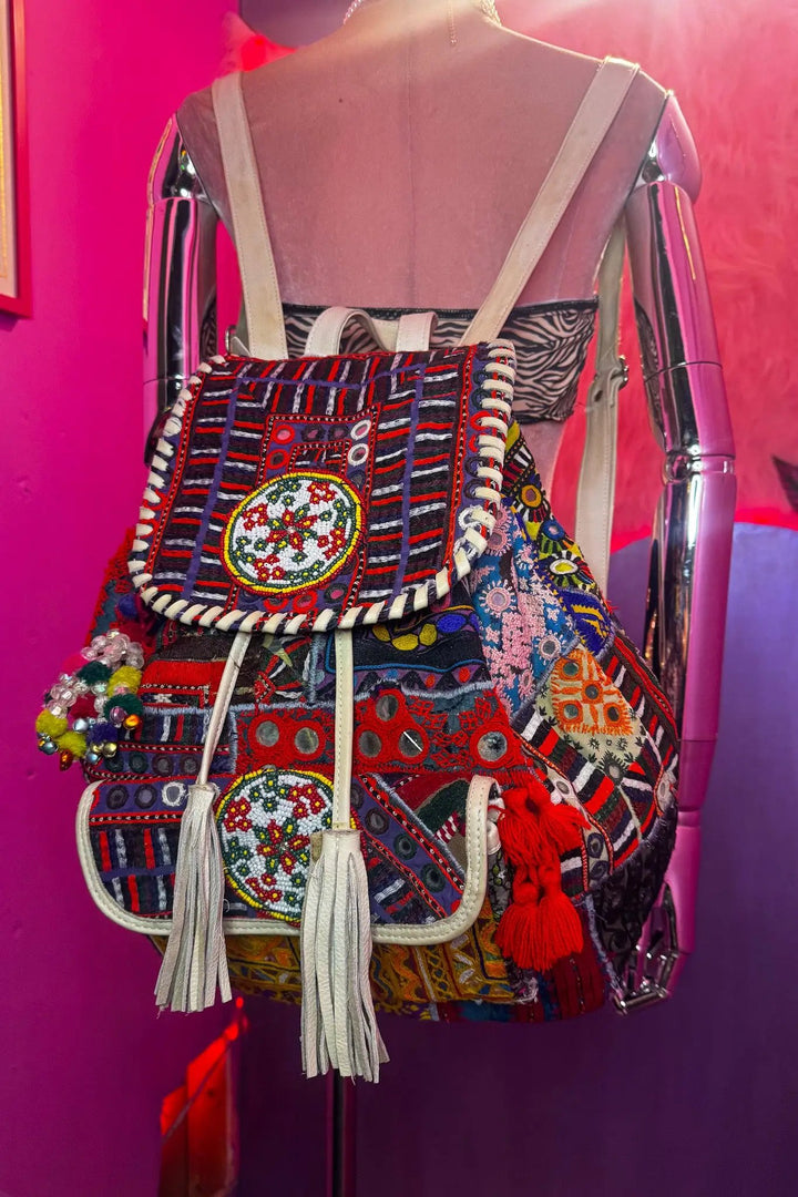 Colorful Poppy Backpack featuring eclectic tribal embroidery and fringe accents, perfect for alternative festival wear by indie brands.
