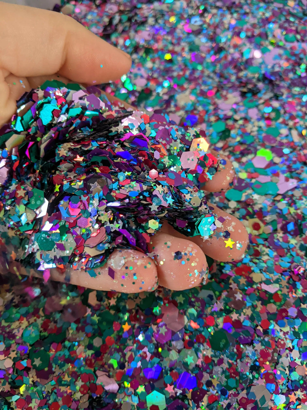 Hand holding vibrant multicolored glitter mix