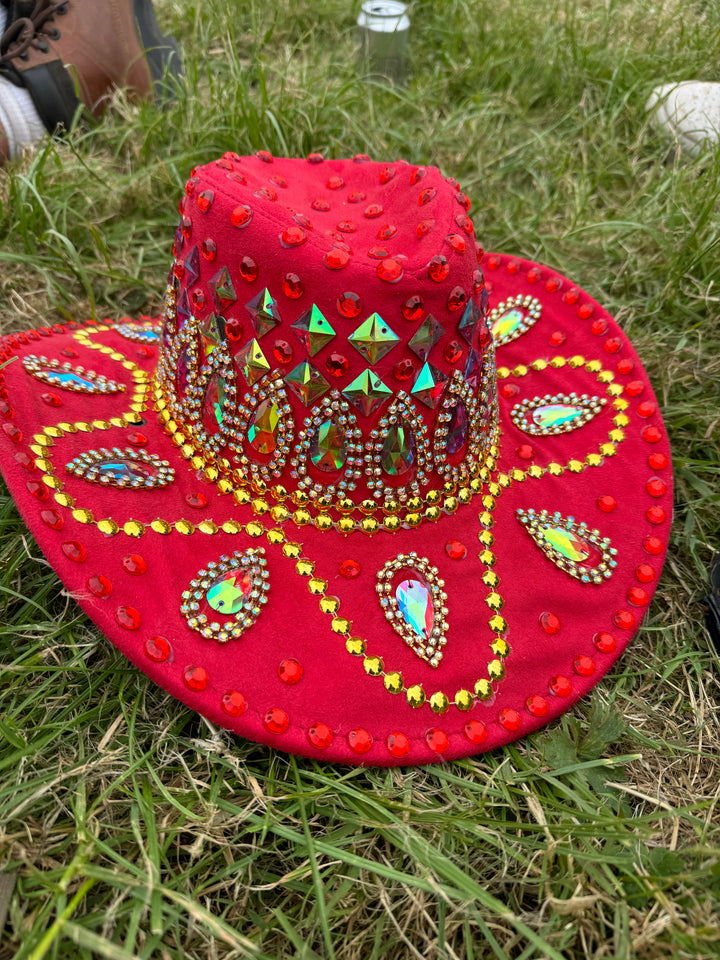 Red cowboy hat adorned with gems on grass