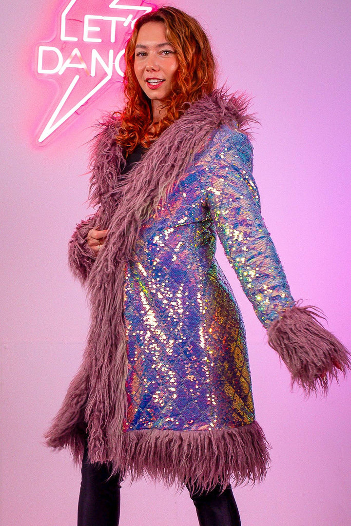 Model wearing lilac sequin coat with fur trim, side view