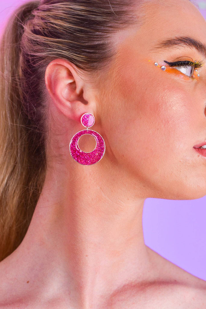 Model wearing bright pink double circle resin earrings