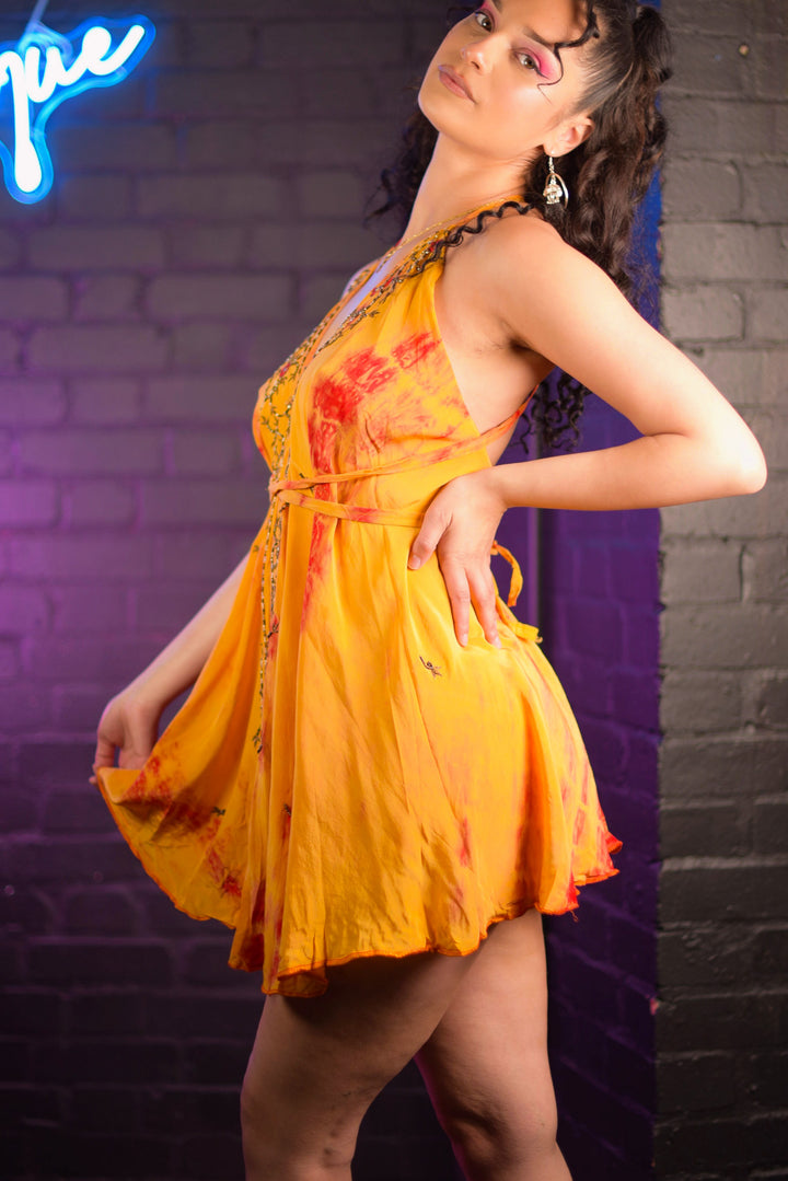 Side view of citrus mini dress with flowing design