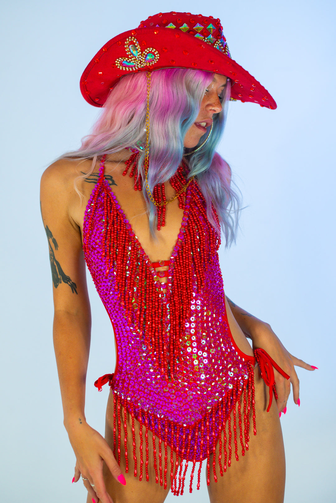 Model wearing red cowboy hat and sequin outfit