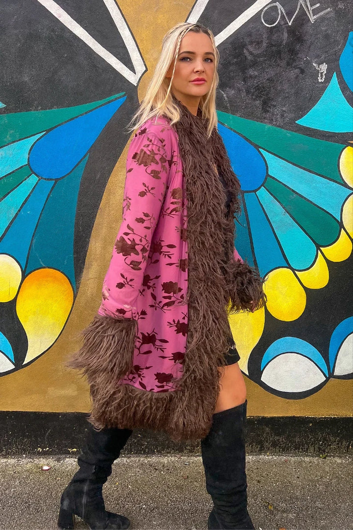 Pink floral coat with brown faux fur trim, walking pose