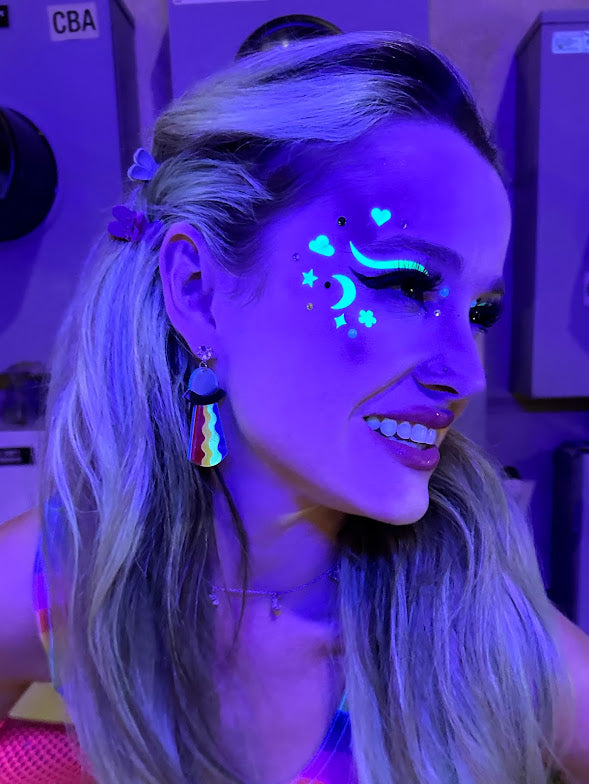 Model with glowing HOLO EYES UV stickers under blacklight.