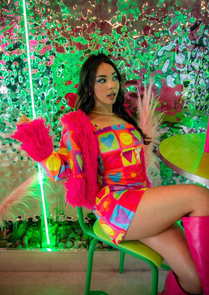 Model in vibrant mini dress and pink fur jacket