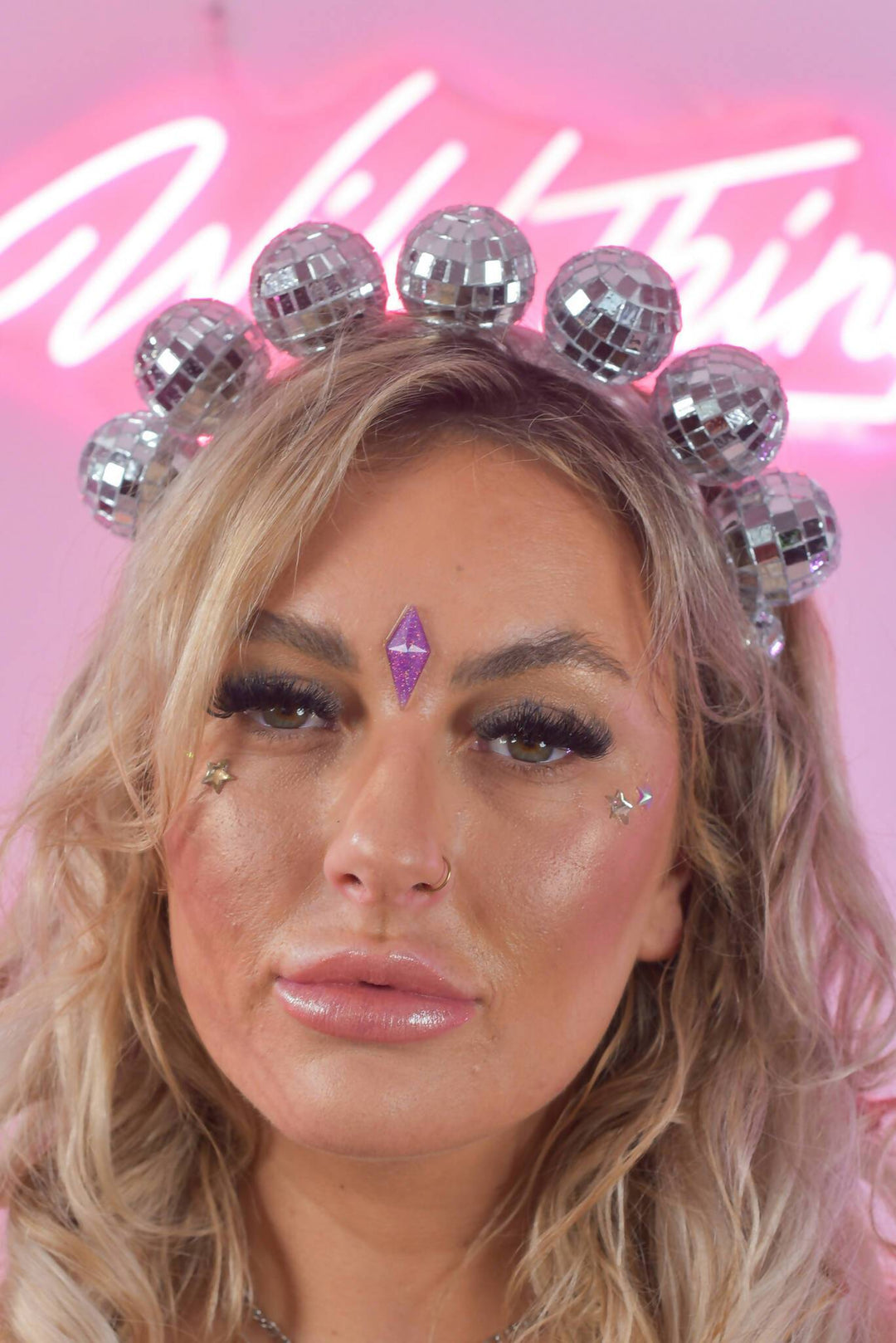 Model wearing baby disco crown headdress with sequins.