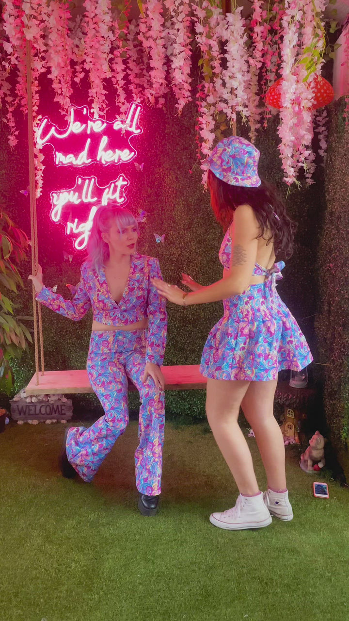 Two models in matching psychedelic outfits with neon sign.