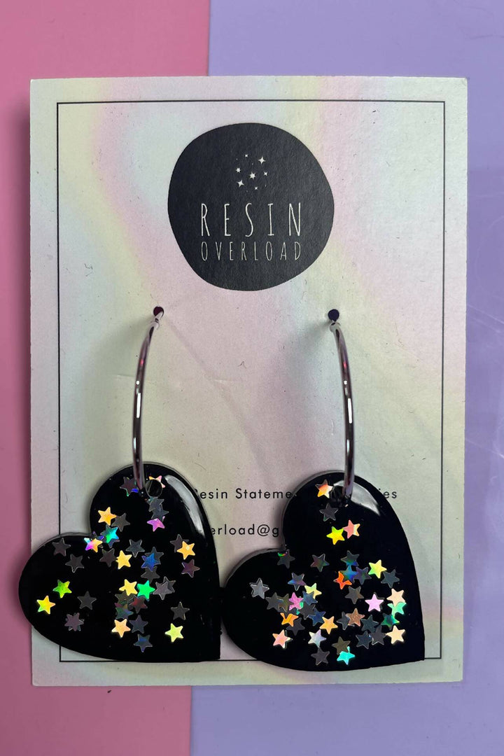 Glittery heart-shaped resin earrings with holographic stars