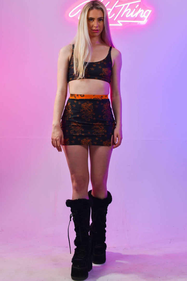 Model in Black Dragon Skirt and orange top, full front view