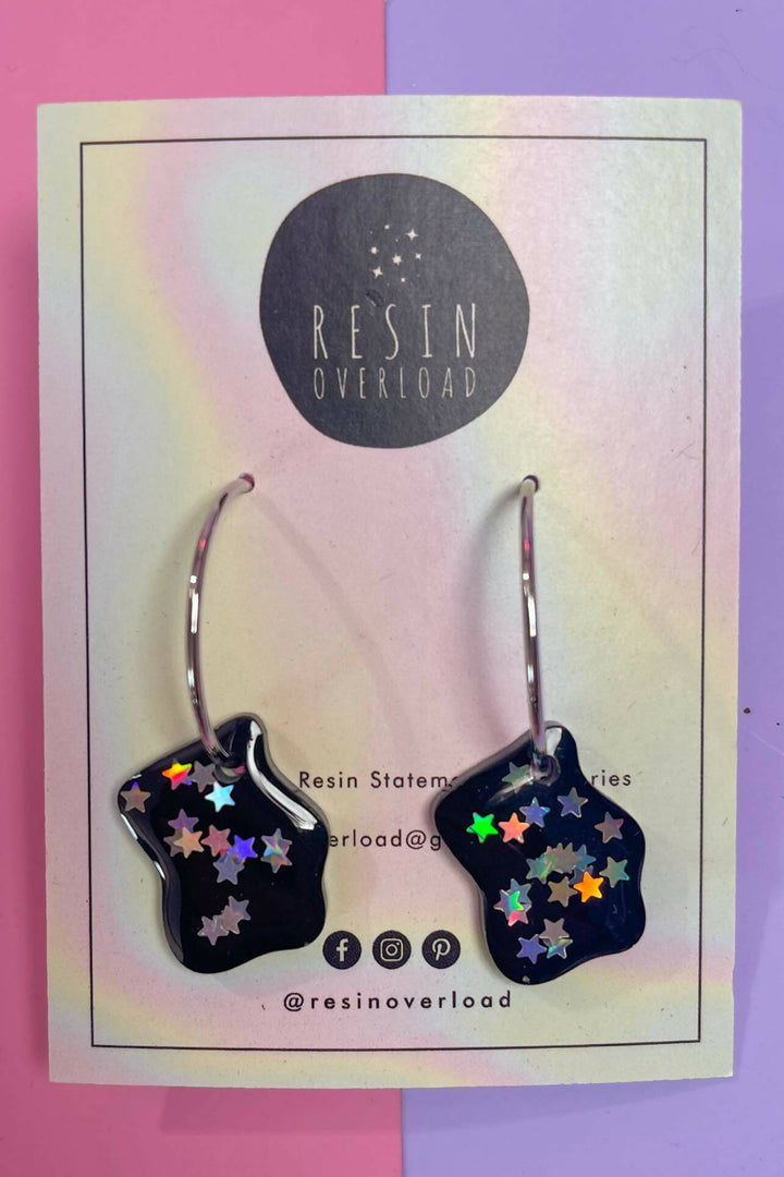 Irregular shaped resin earrings with holographic stars on card