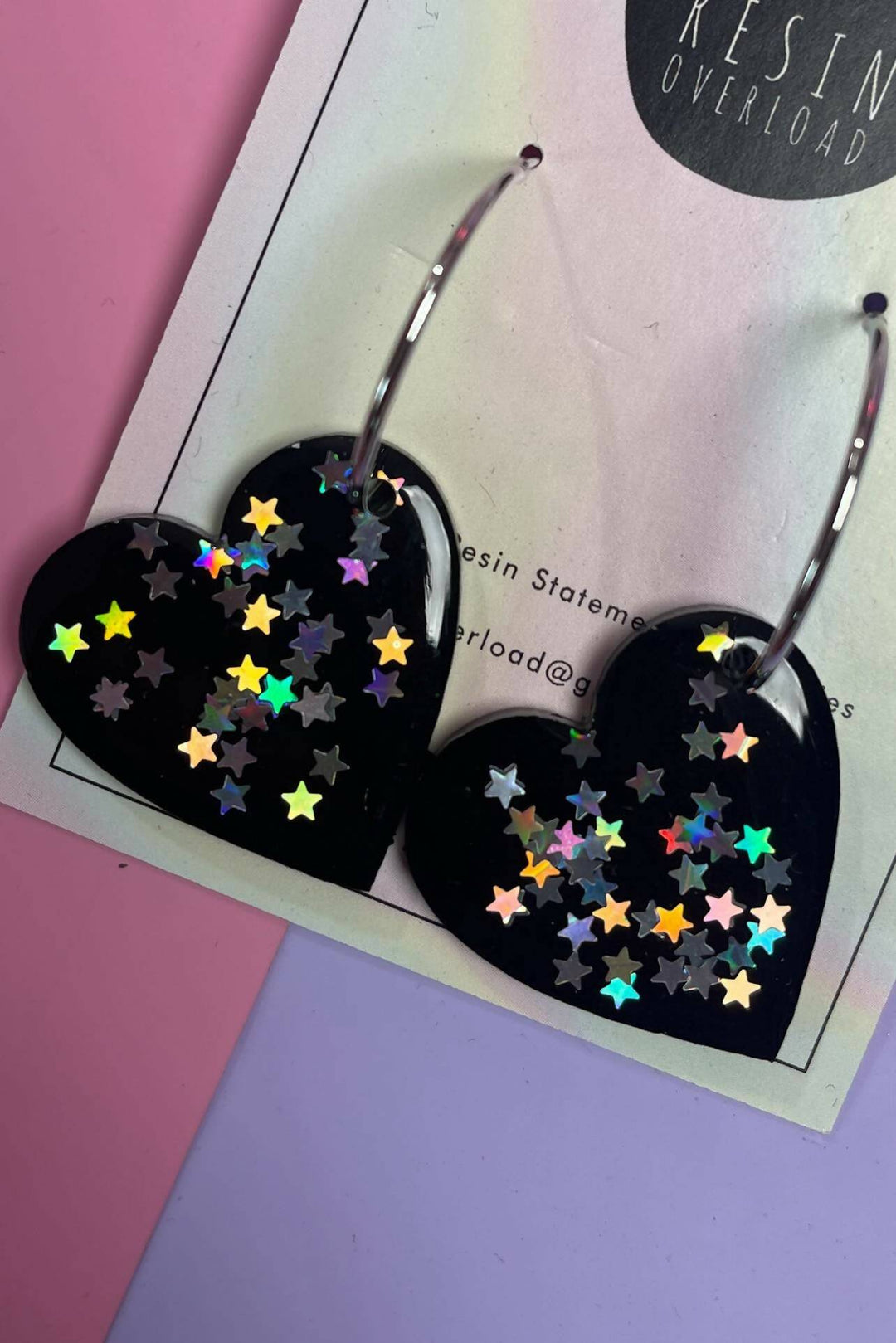 Close-up of heart-shaped resin earrings with sparkly stars