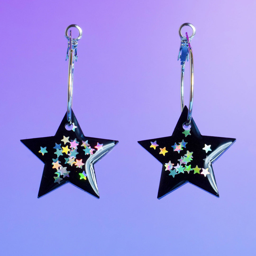 Starry night themed silver hoop earrings with resin stars.