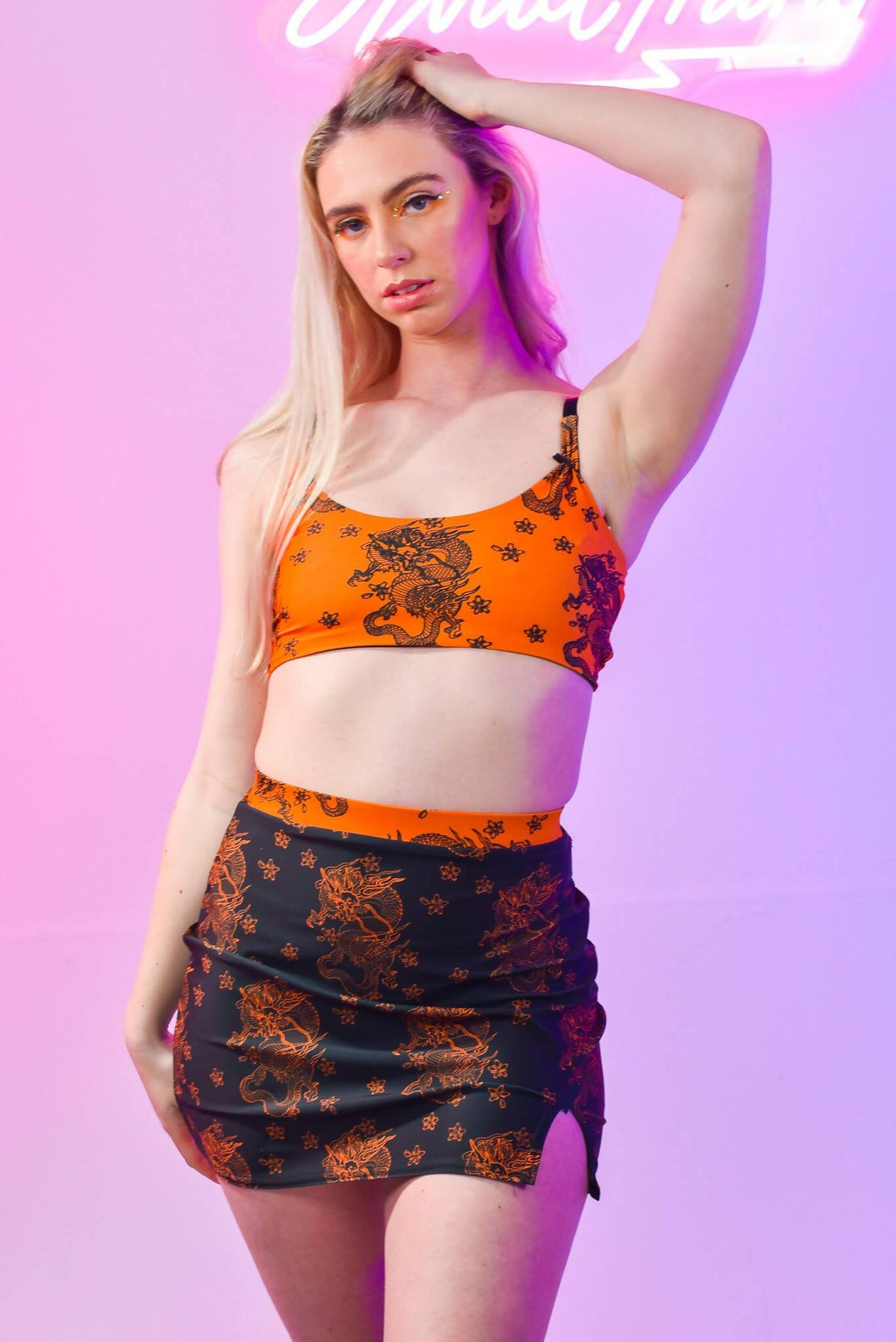 Model wearing Black Dragon Skirt with orange top, front view