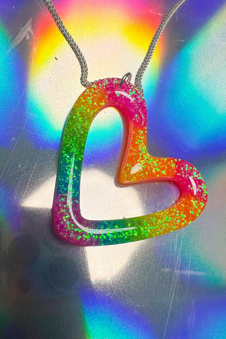 Rainbow resin heart necklace with glitter on holographic surface