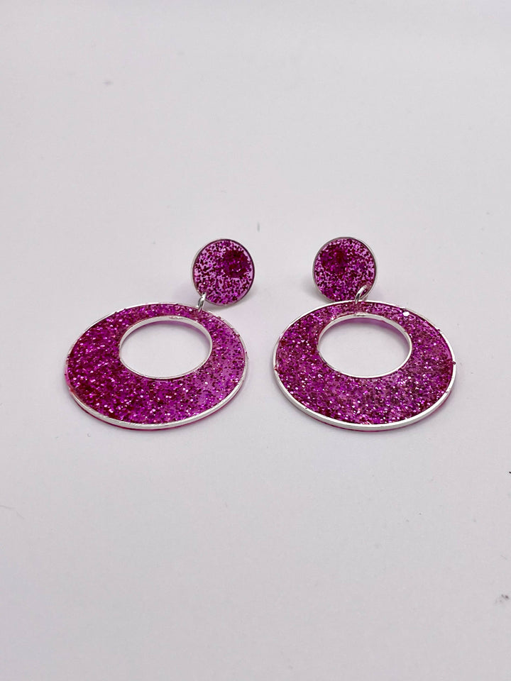 Bright pink double circle resin earrings on white background