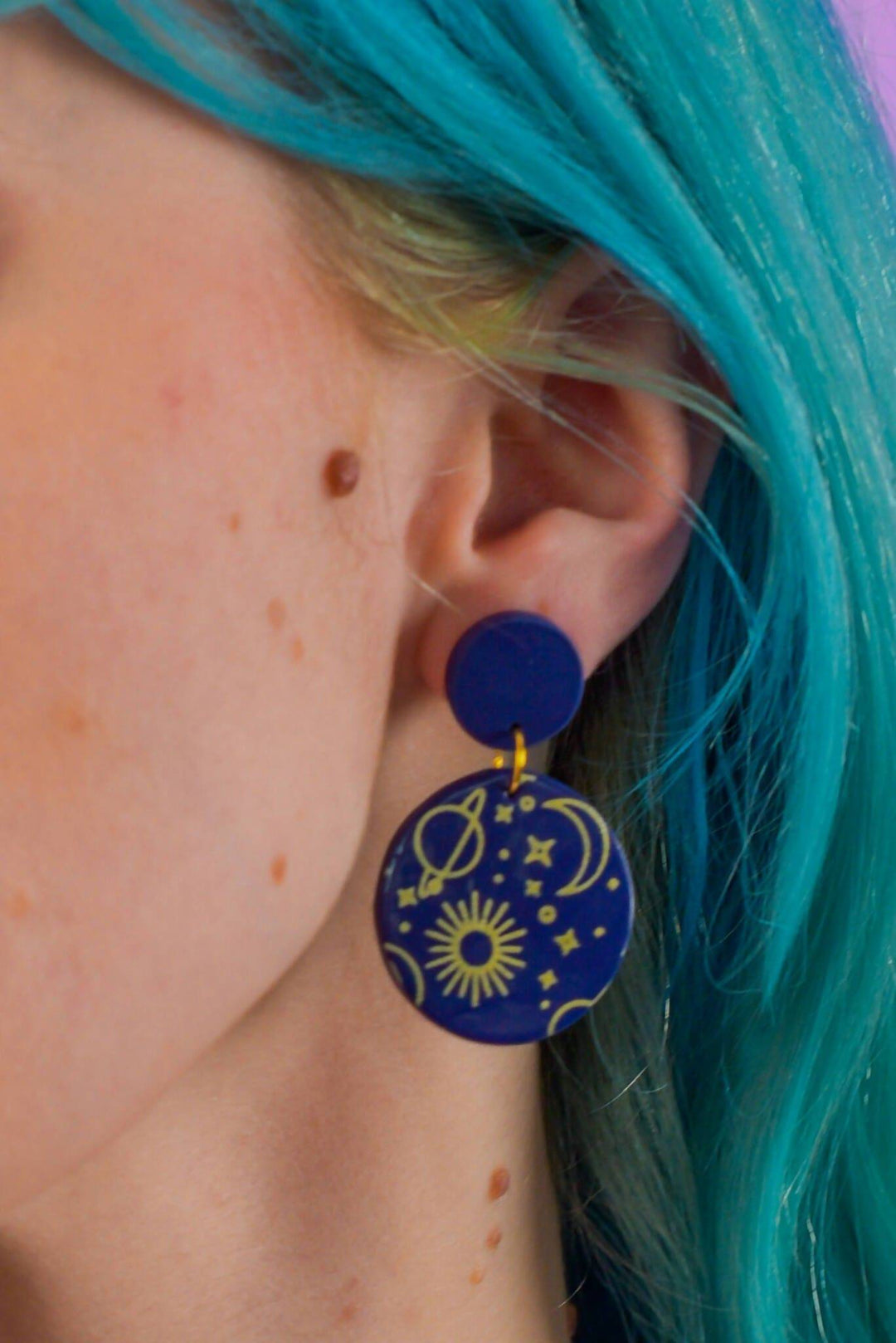 Blue space-themed dangle earring with celestial designs