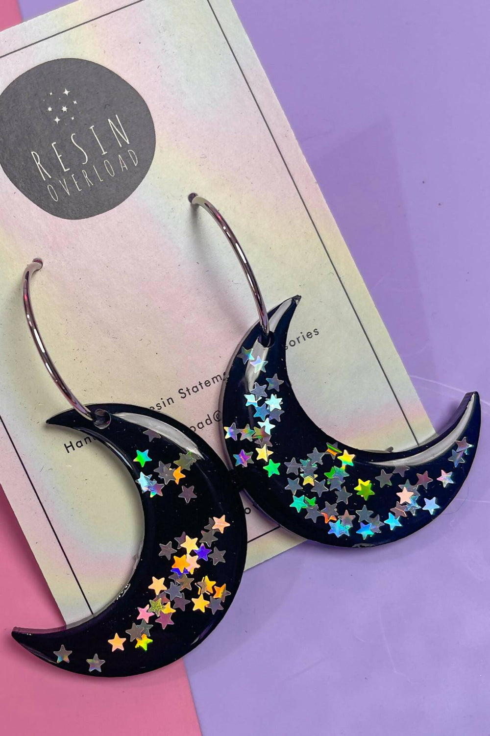 Crescent moon earrings featuring holographic star design.