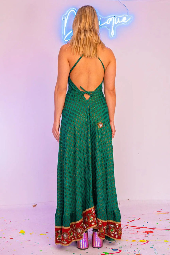 Back view of green maxi dress with open back and floral trim