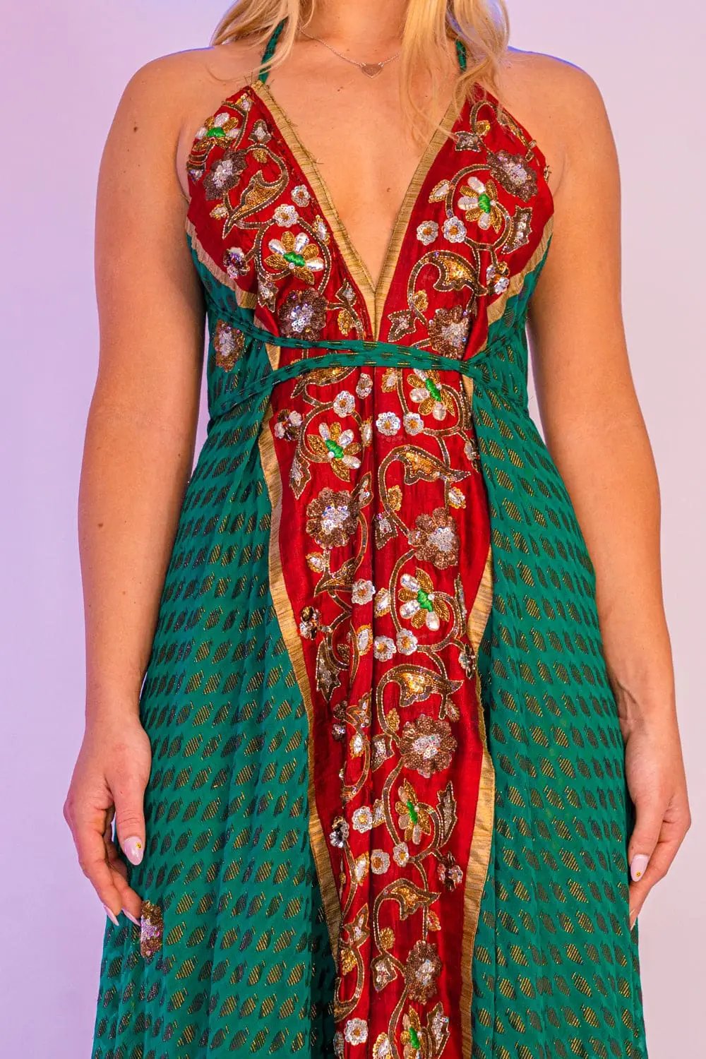 Close-up of green maxi dress with intricate red floral design