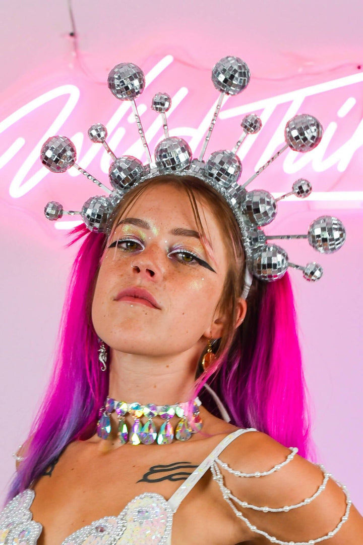 Model wearing disco ball crown headdress and holographic choker.