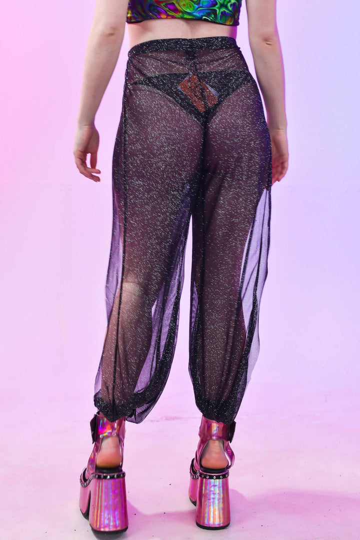 Back view of black mesh cuffed trousers, highlighting sheer design.