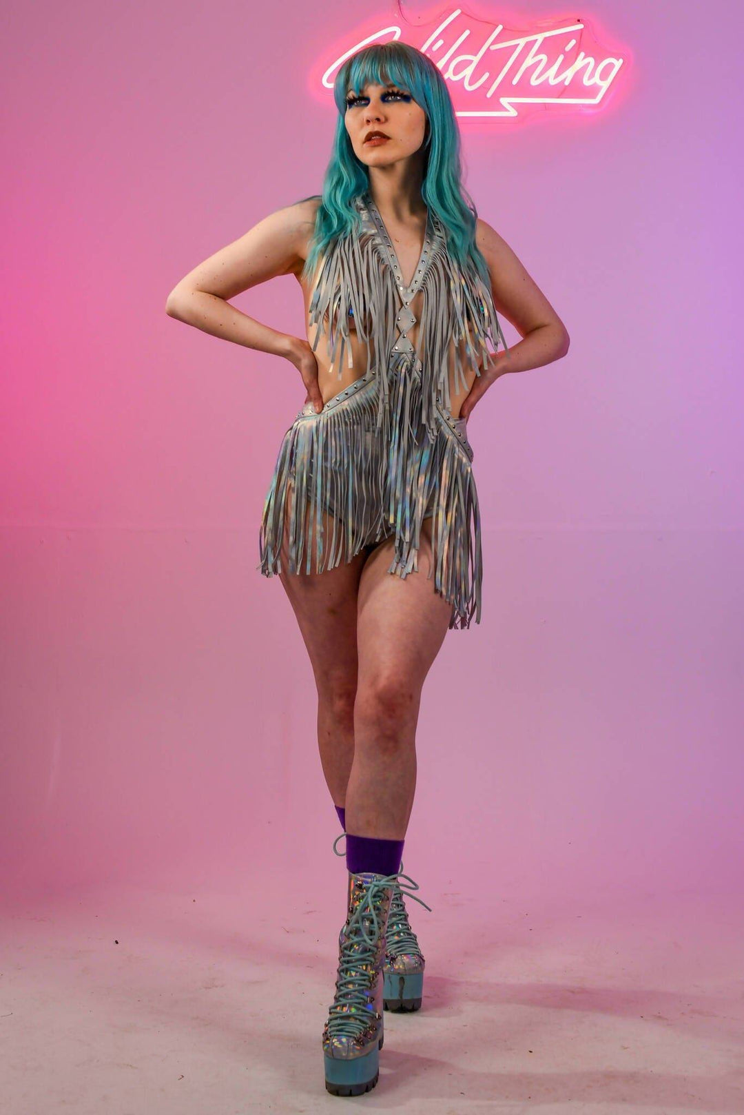 Model with hands on hips in holographic silver fringe dress.