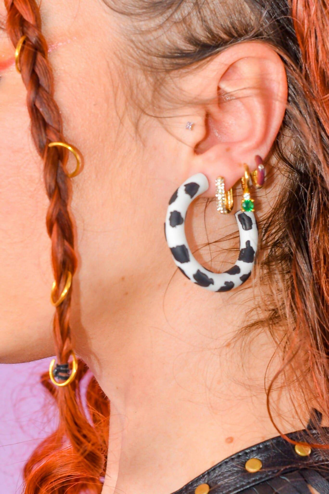 Polymer clay cow print hoop earring on ear