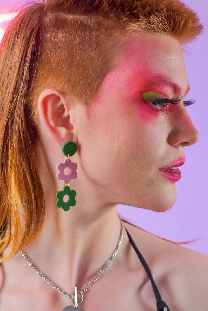 Side view of model with pink and green daisy earrings