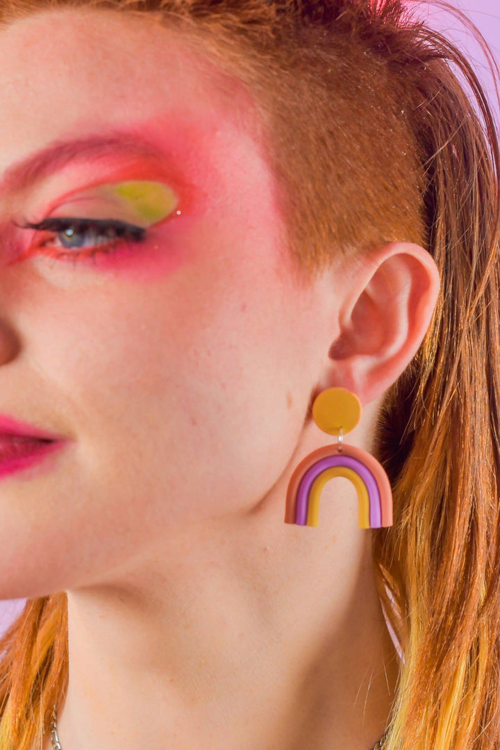 Pastel rainbow dangle earrings on model