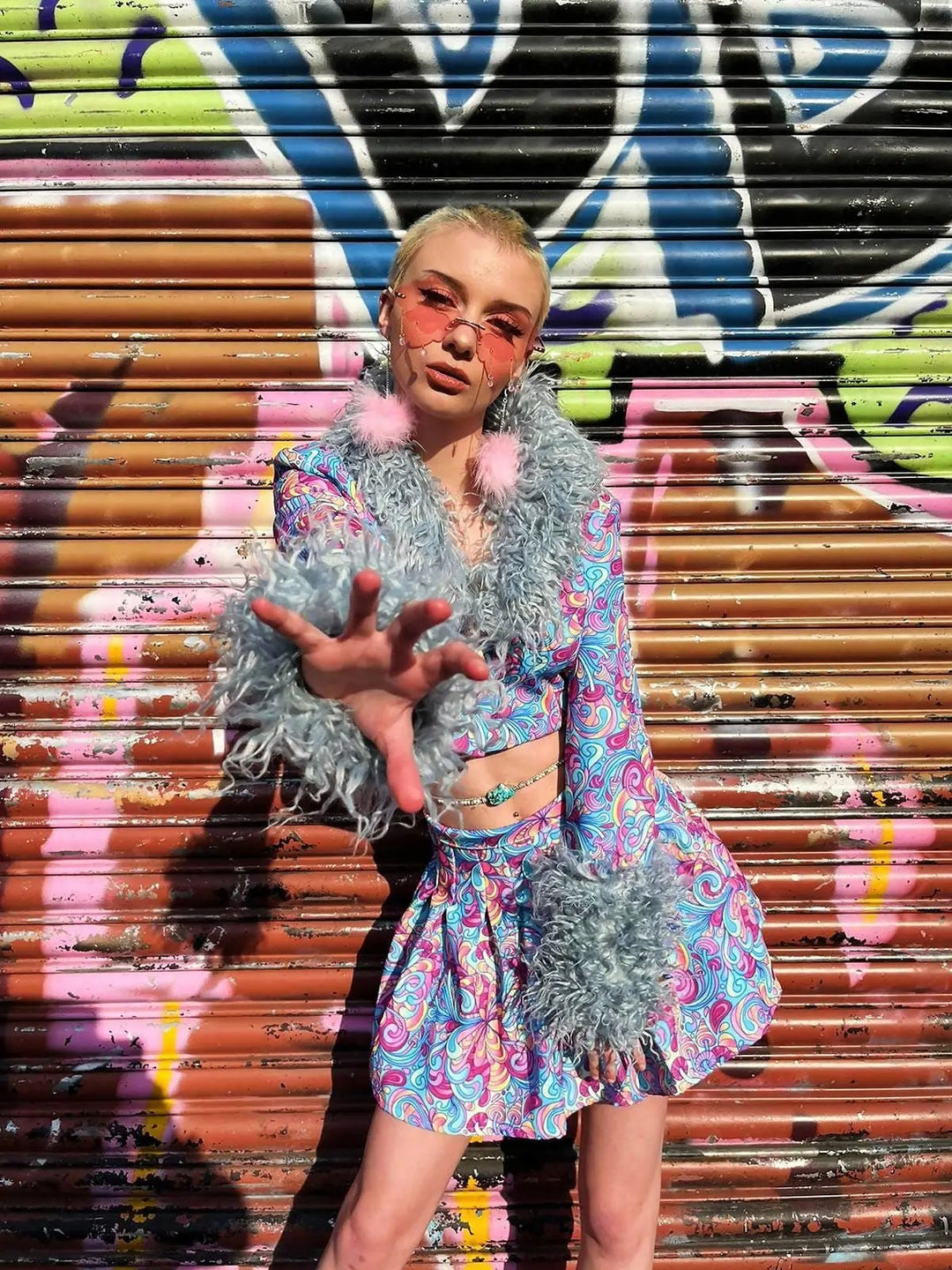 Model posing in Shroom Tennis Skirt with graffiti