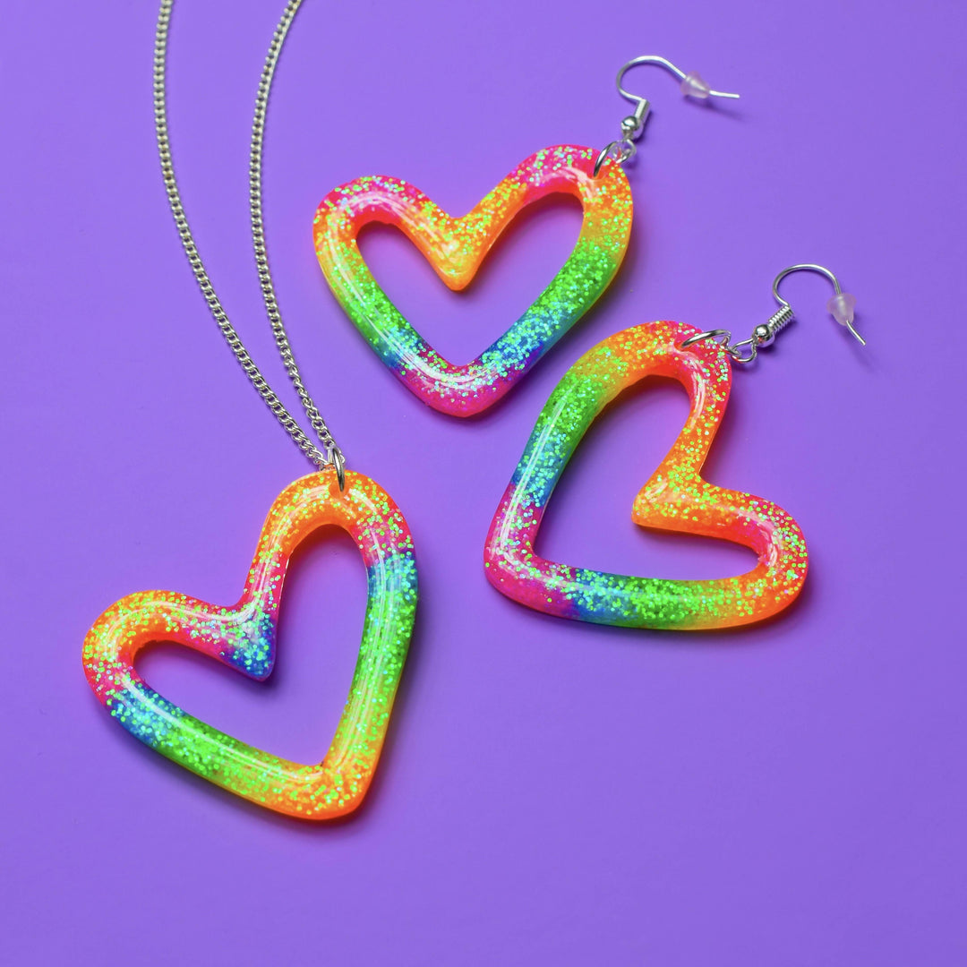 Rainbow resin heart earrings and necklace on purple background